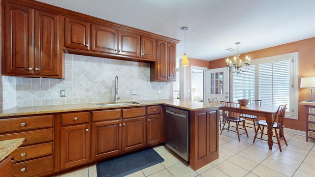 kitchen with light stone counters, brown cabinetry, an inviting chandelier, a sink, and dishwasher