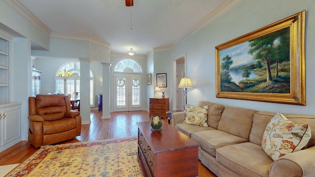 living room with ornate columns, french doors, light wood-style floors, and ornamental molding