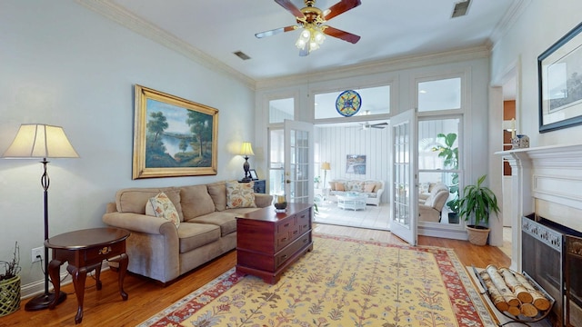 living area featuring visible vents, ceiling fan, and ornamental molding