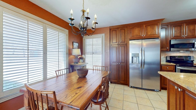 dining space with light tile patterned floors and a chandelier