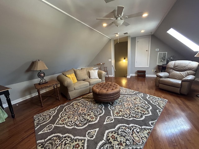 living area with lofted ceiling with skylight, baseboards, ceiling fan, and wood finished floors