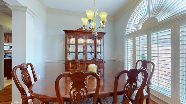 dining area with a notable chandelier, a wealth of natural light, and ornamental molding