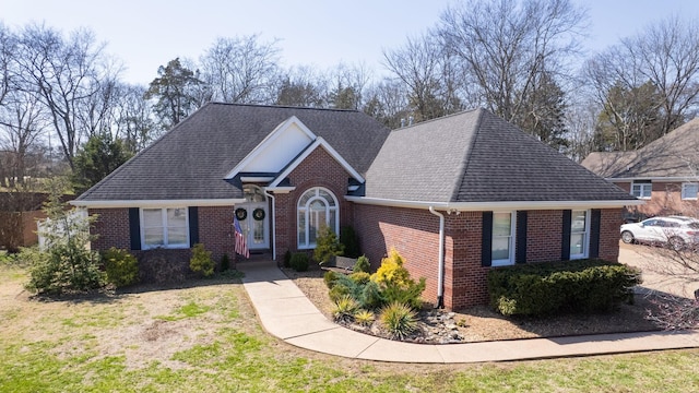 view of front facade featuring brick siding and a shingled roof