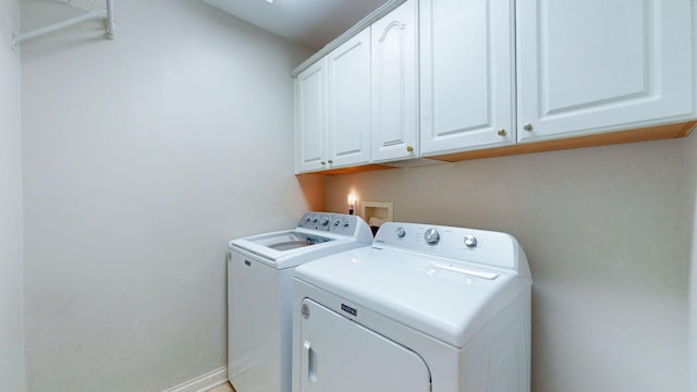 laundry room with baseboards, cabinet space, and independent washer and dryer