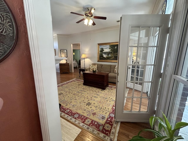 interior space with ceiling fan, wood finished floors, and crown molding