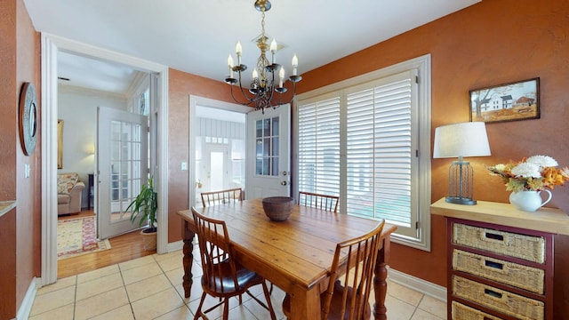 dining room with light tile patterned floors, baseboards, and a notable chandelier