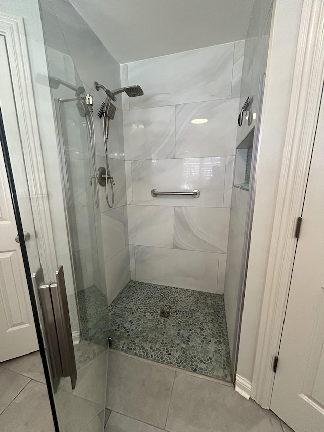 bathroom featuring tile patterned flooring and a shower stall