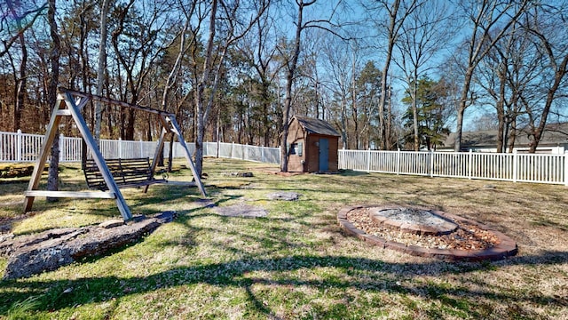 view of yard with an outbuilding, a storage unit, and a fenced backyard