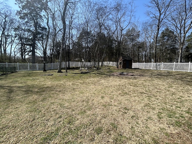 view of yard featuring a storage shed, an outdoor structure, and a fenced backyard