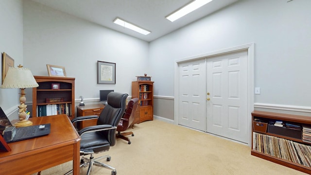 carpeted office featuring lofted ceiling and baseboards