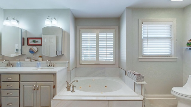 bathroom featuring a sink, toilet, a tub with jets, and double vanity