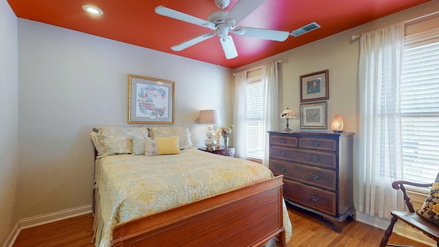 bedroom with visible vents, light wood-style flooring, baseboards, and multiple windows