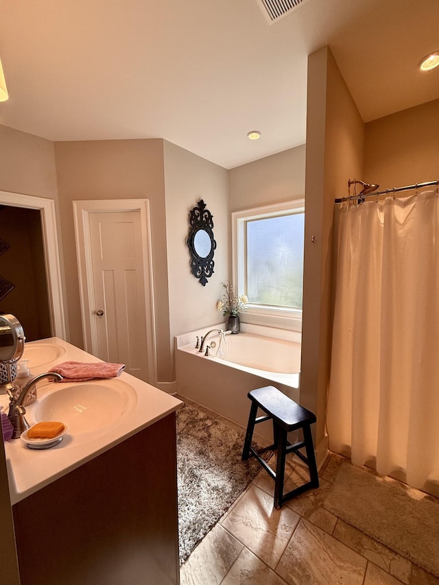 full bath featuring vanity and a garden tub