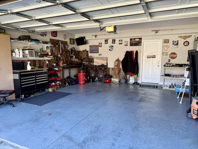 garage with a workshop area and a garage door opener