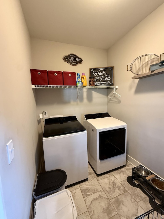 laundry area with laundry area, baseboards, and washing machine and clothes dryer