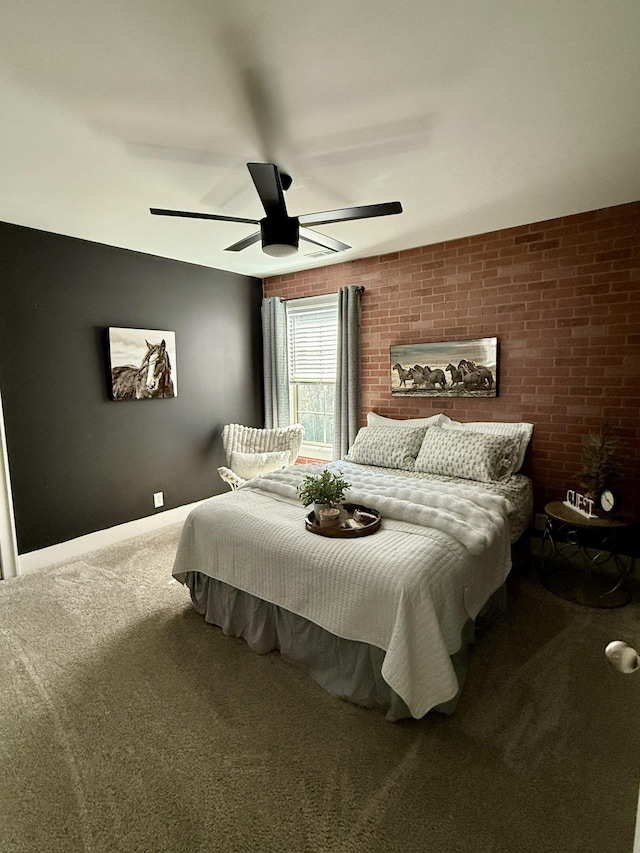 carpeted bedroom with baseboards, brick wall, and a ceiling fan