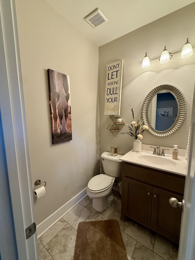 half bath with vanity, toilet, baseboards, and visible vents