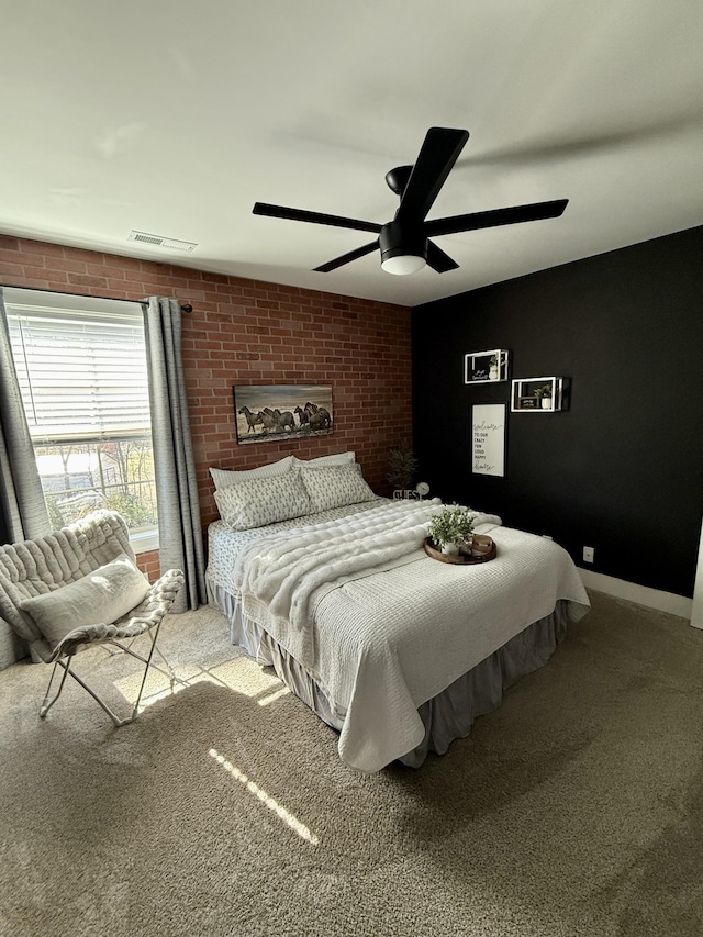 bedroom featuring a ceiling fan, visible vents, brick wall, baseboards, and carpet flooring