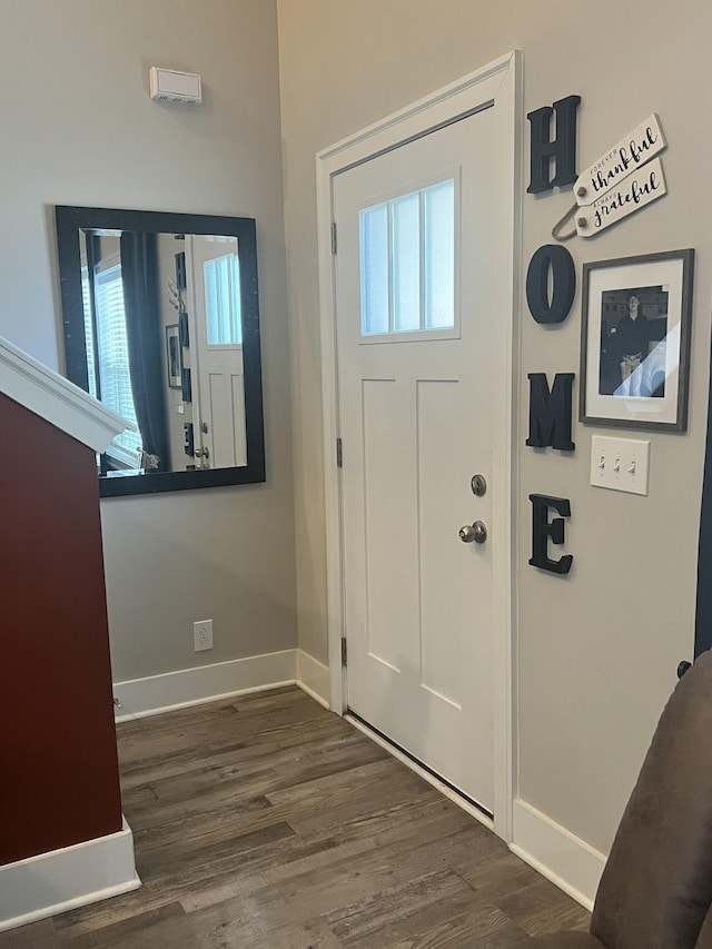 entrance foyer featuring a healthy amount of sunlight, baseboards, and dark wood-style flooring