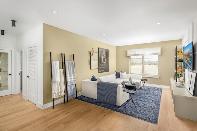 living area featuring recessed lighting, baseboards, and light wood finished floors