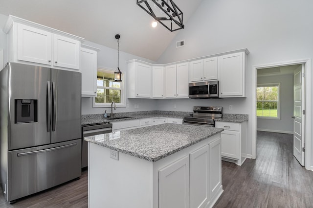 kitchen with stainless steel appliances, a wealth of natural light, white cabinetry, and a sink