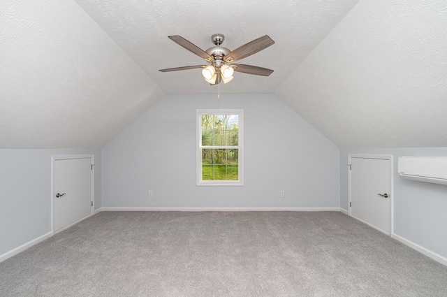 bonus room with a wall mounted air conditioner, carpet flooring, and vaulted ceiling