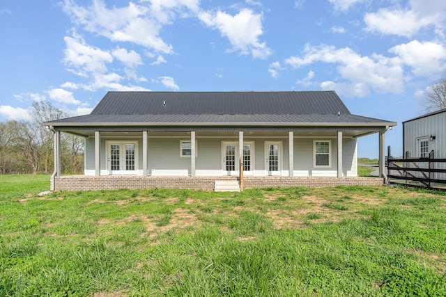 back of property featuring a yard, metal roof, and covered porch