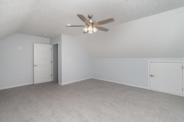 additional living space featuring carpet, ceiling fan, baseboards, and lofted ceiling