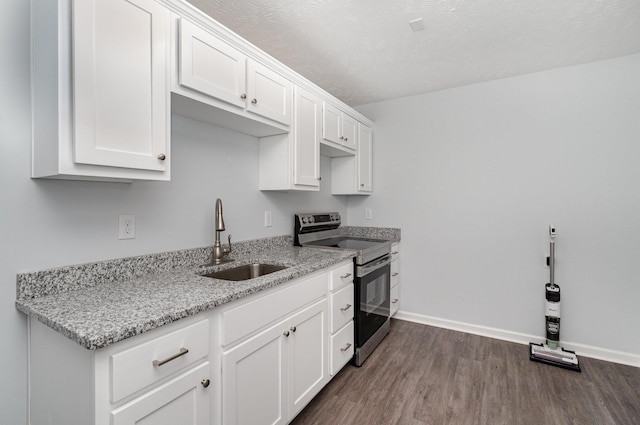 kitchen with light stone countertops, dark wood-type flooring, white cabinetry, a sink, and electric stove