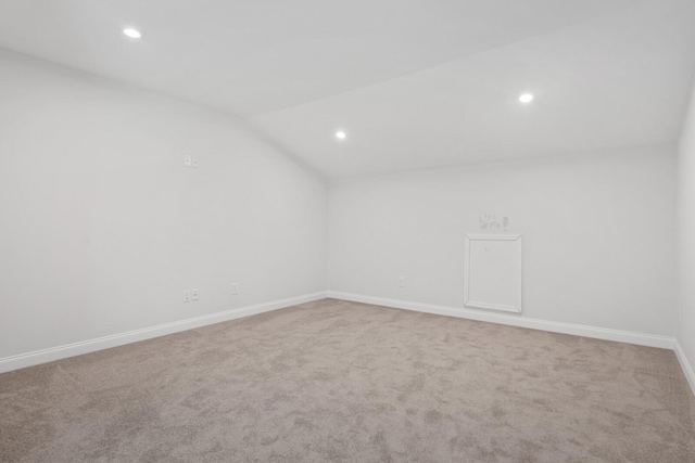 carpeted spare room with vaulted ceiling, recessed lighting, and baseboards