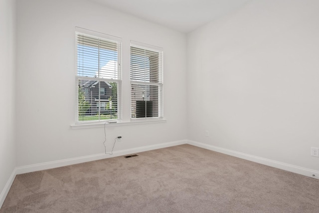 unfurnished room with visible vents, baseboards, and carpet flooring