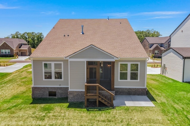 rear view of house featuring a yard and a sunroom