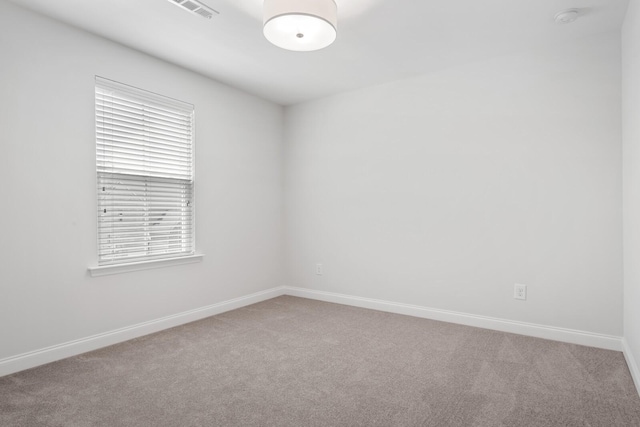 carpeted empty room with baseboards and visible vents