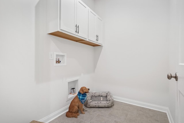 washroom featuring washer hookup, cabinet space, and baseboards