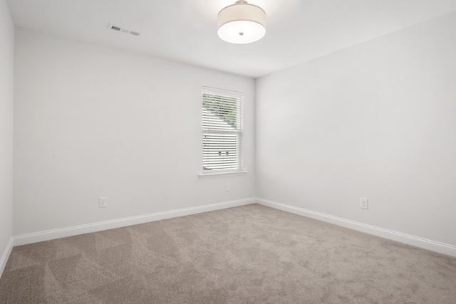 empty room featuring visible vents, baseboards, and carpet flooring