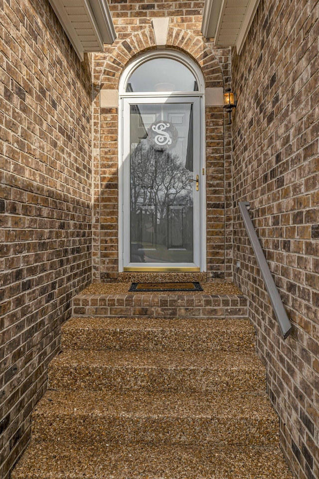 doorway to property featuring brick siding