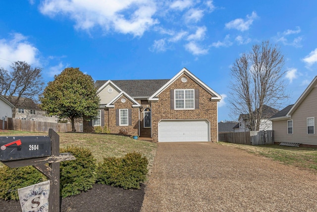 traditional-style house featuring fence, driveway, an attached garage, a front lawn, and brick siding