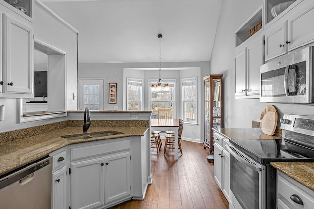 kitchen with a sink, stainless steel appliances, white cabinets, and hardwood / wood-style flooring