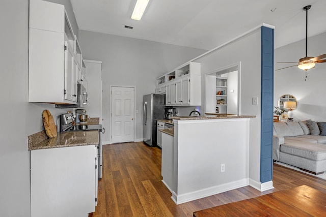 kitchen featuring open floor plan, white cabinets, appliances with stainless steel finishes, and dark wood-type flooring