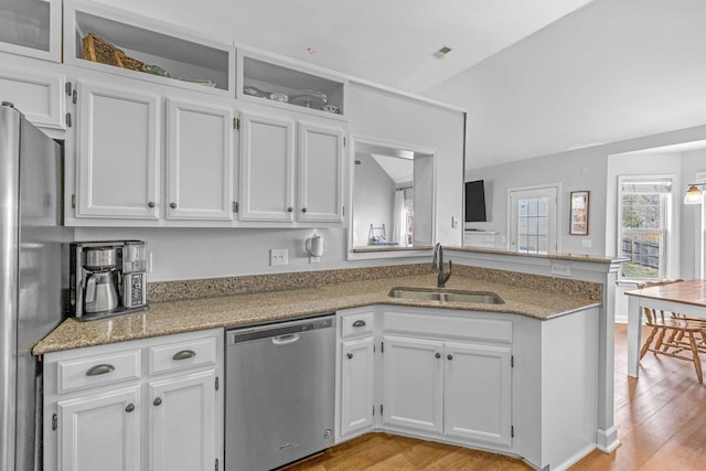 kitchen featuring a sink, a peninsula, white cabinetry, and stainless steel appliances