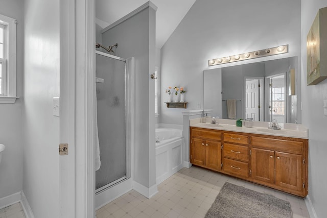 full bathroom featuring double vanity, a shower stall, a garden tub, and a sink