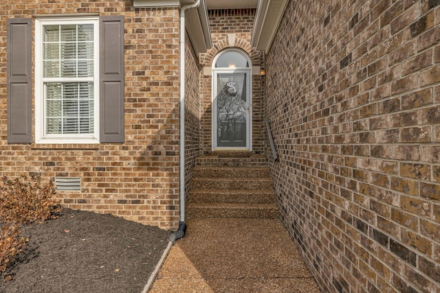 view of exterior entry featuring brick siding