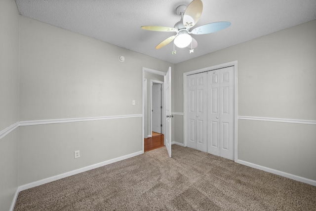 unfurnished bedroom with a textured ceiling, carpet, a closet, and baseboards