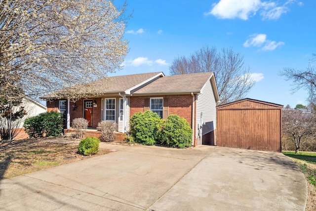 ranch-style home with brick siding, an outbuilding, and roof with shingles