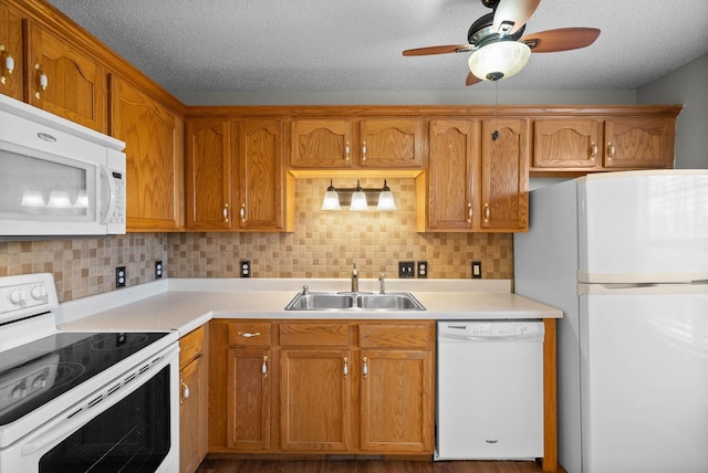 kitchen featuring a sink, white appliances, light countertops, decorative backsplash, and ceiling fan