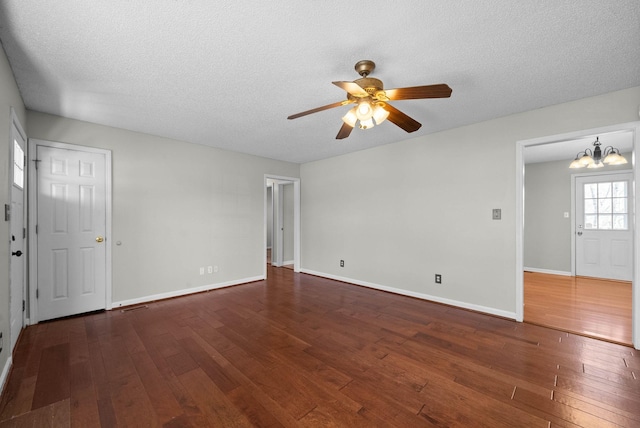 unfurnished living room with ceiling fan with notable chandelier, a textured ceiling, and hardwood / wood-style floors