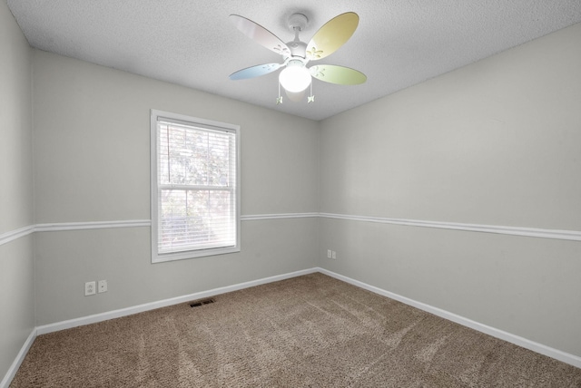 carpeted empty room with baseboards, a ceiling fan, visible vents, and a textured ceiling