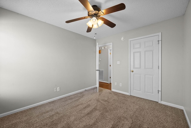 unfurnished bedroom with a ceiling fan, baseboards, visible vents, a textured ceiling, and carpet flooring