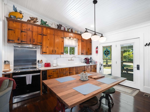 kitchen with brown cabinets, backsplash, dark wood-style floors, electric range oven, and light countertops