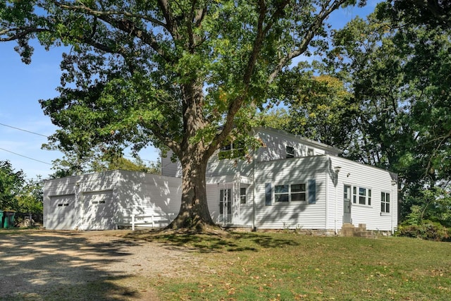 view of home's exterior featuring a yard, entry steps, an outdoor structure, and a detached garage
